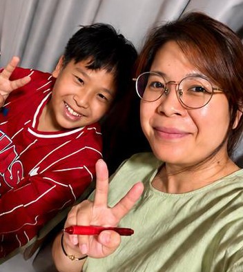 Mrs Aw smiling with a student